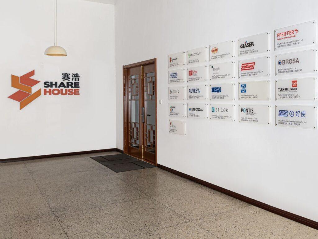 Sharehouse China lobby with a wall displaying partner companies' nameplates